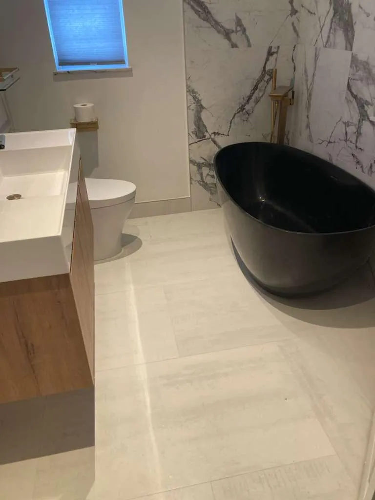 Finished bathroom with fixtures, supply lines and drain set by the Raber crew