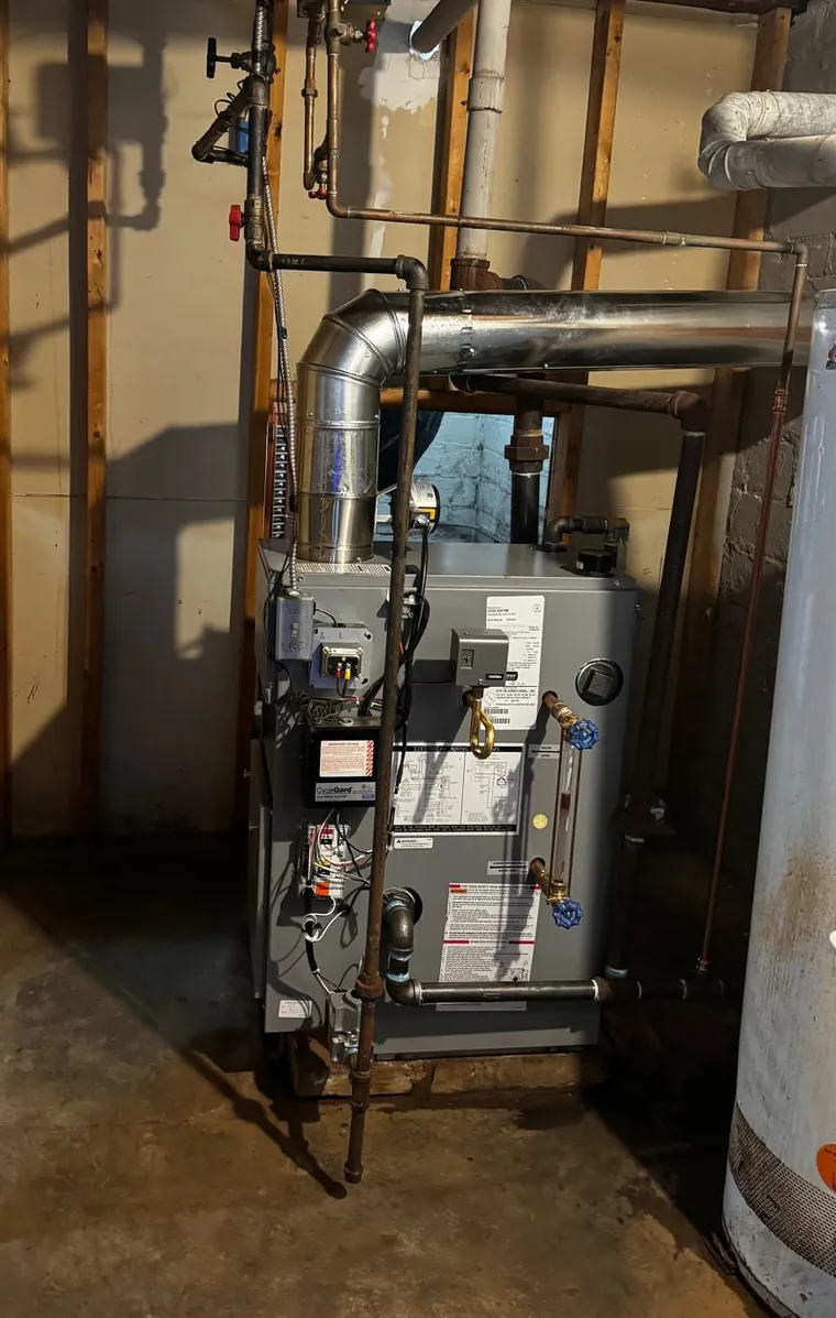 Basement mechanical room in a Northeast Ohio home, with the flue, gas train and insulated ductwork Raber inspects on an indoor air quality visit