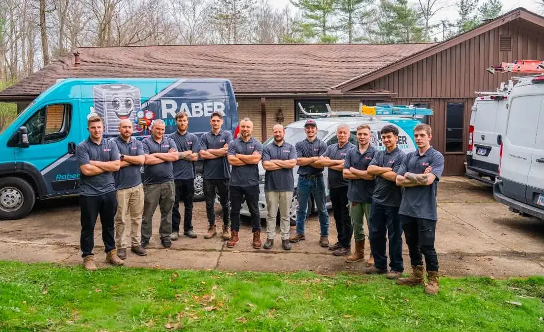The Raber HVAC team lined up in front of the company service vans
