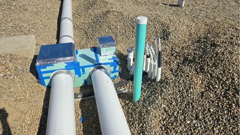 Close up of under slab drain stub outs with protective insulation wrap ahead of a concrete pour